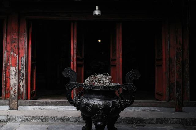 Đỉnh đồng nắp lân đặt trước cửa đền sơn đỏ